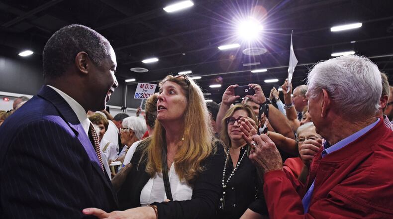 Republican presidential candidate Dr. Ben Carson greets Marjorie Pitzer in the front row after a campaign rally Tuesday at the Sharonville Convention Center.