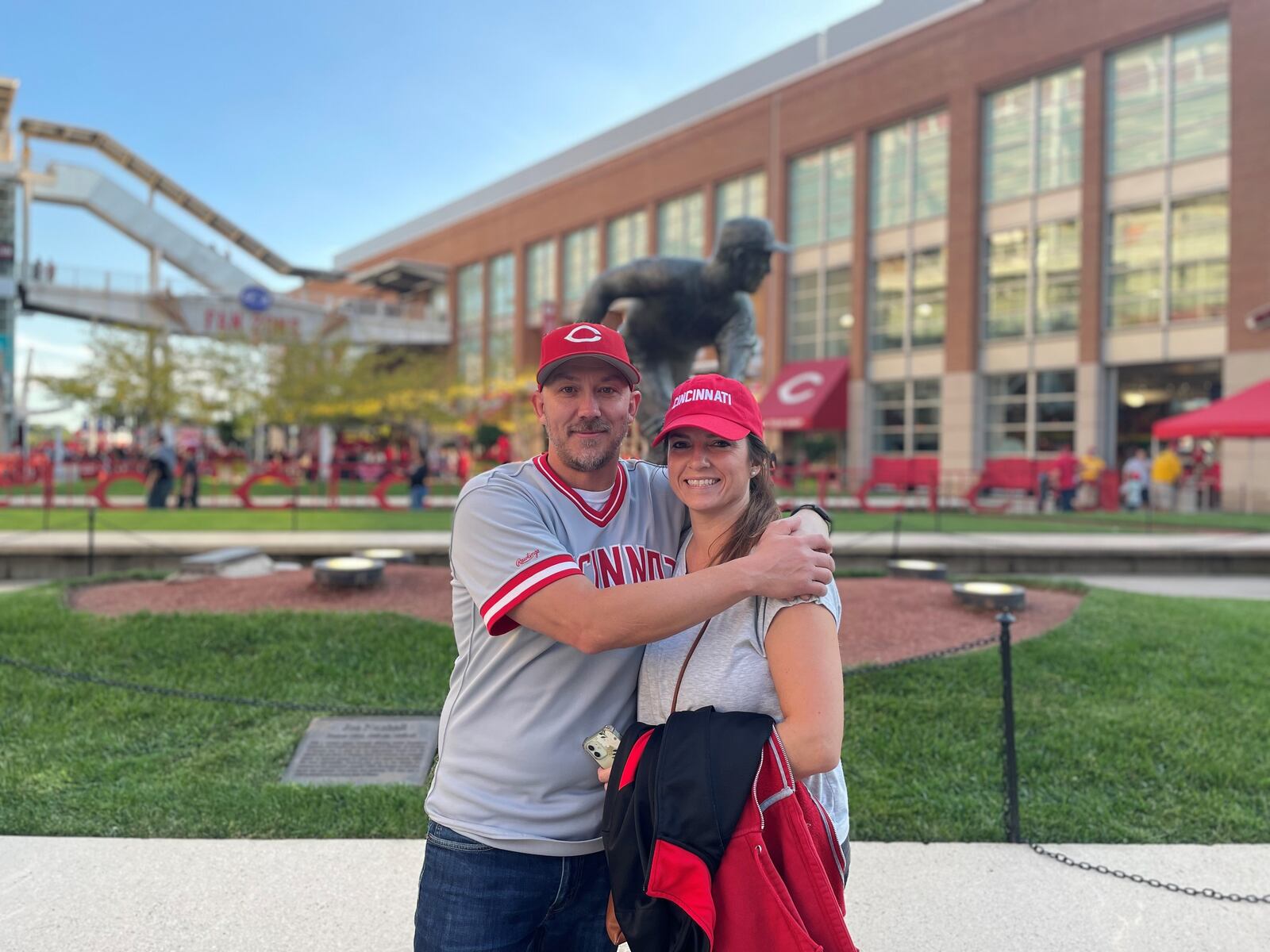 Ben Otto and his wife, Laura, celebrate his walk from their Fairfield home to Great American Ball Park Friday night. He walked 21.5 miles and raised nearly $12,000 for the Joe Nuxhall Miracle League. They posed in front of Nuxhall's statue. SUBMITTED PHOTO