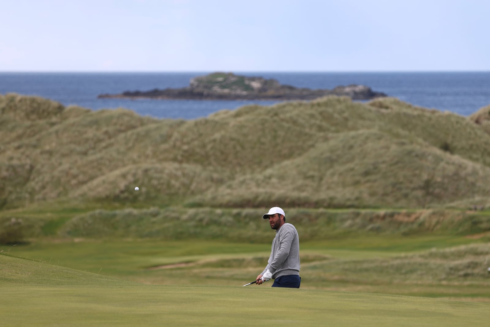 Scottie Scheffler of the United States plays onto the 16th green during a practice round for the 2025 British Open golf championship at the Royal Portrush Golf Club, Northern Ireland, Monday, July 14, 2025. (AP Photo/Peter Morrison)