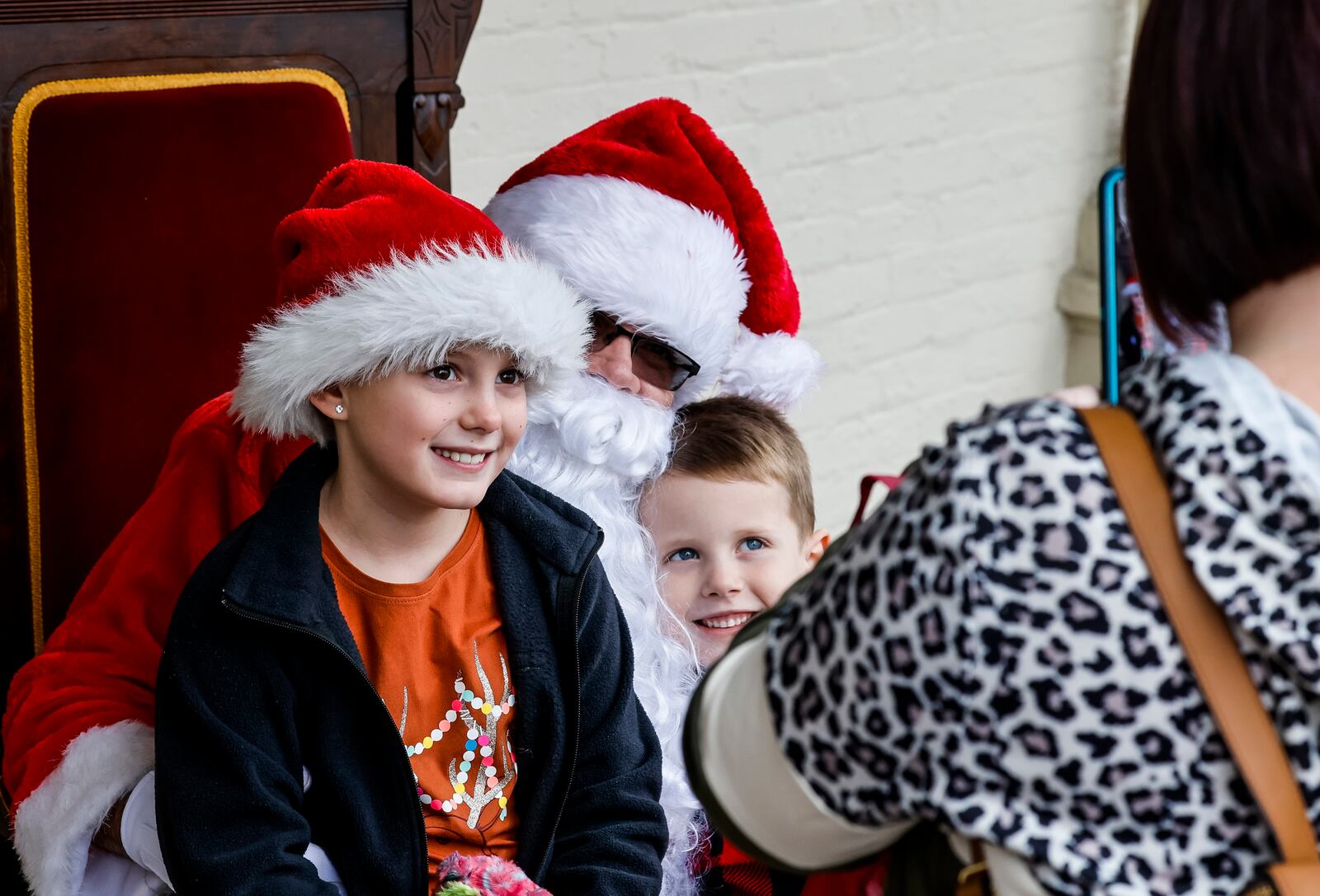 The German Village Christmas Walk was held Sunday, Dec. 5, 2021 in Hamilton. Businesses and homes were decorated for the holidays and musicians performed to offer a glimpse of German Village Christmas nostalgia. Reesely Pendergest, 8, and Ryder Pendergest, 6, get their picture taken with Santa at the Butler County Historical Society. NICK GRAHAM / STAFF