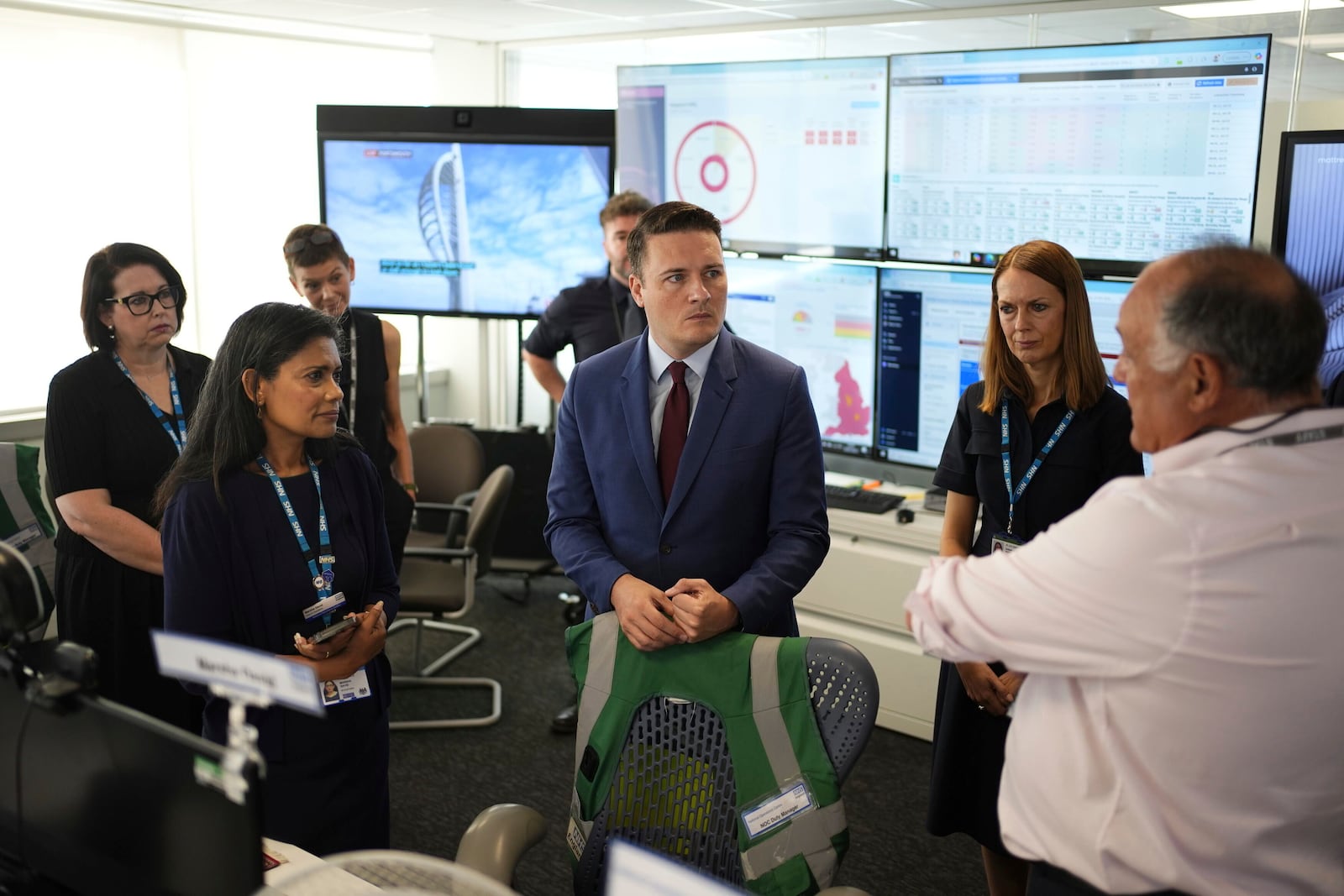 Britain's Health Secretary Wes Streeting, center, listens during a visit to NHS National Operations Centre to see how they manage industrial action, in London, Friday, July 25, 2025. (Jordan Pettitt/PA via AP)