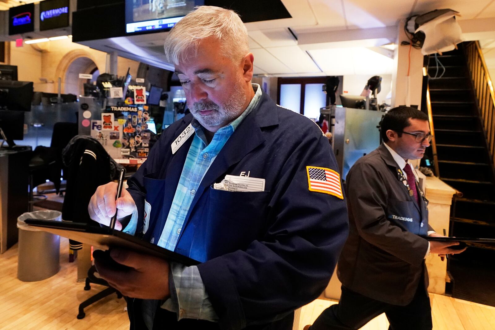 Trader Edward McCarthy, left, works on the floor of the New York Stock Exchange, Tuesday, April 15, 2025. (AP Photo/Richard Drew)