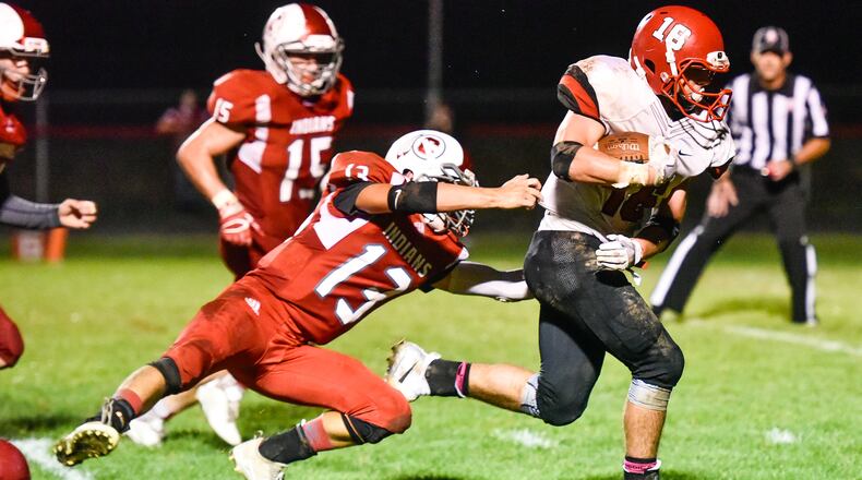Madison’s Tyler Baumgartner carries the football for a touchdown as he is guarded by Carlisle’s Sammy Reed during their game Friday, Oct. 6 at Carlisle High School. Madison won 31-14. NICK GRAHAM/STAFF