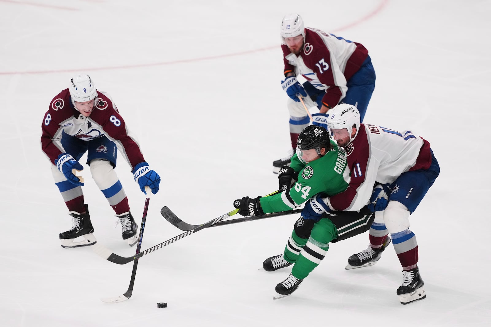 Dallas Stars center Mikael Granlund (64) works for control of the puck against Colorado Avalanche's Cale Makar (8), Valeri Nichushkin (13) and Brock Nelson (11) in the third period in Game 7 of a first-round NHL hockey playoff series Saturday, May 3, 2025, in Dallas. (AP Photo/Julio Cortez)