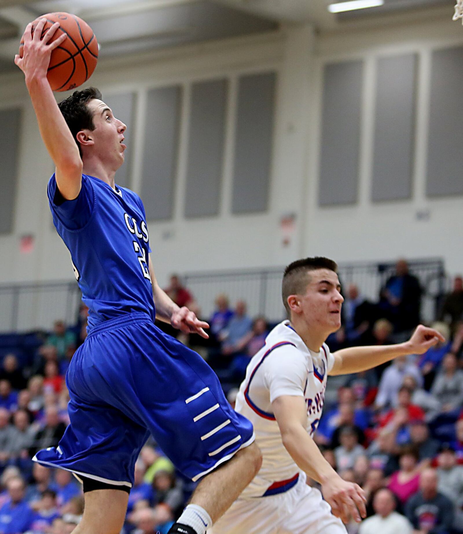 Cincinnati Christian’s Brady Roberts is fouled by New Madison Tri-Village’s Dillon McCullough on a drive to the basket Tuesday night during their Division IV regional semifinal at Fairmont’s Trent Arena. CONTRIBUTED PHOTO BY E.L. HUBBARD