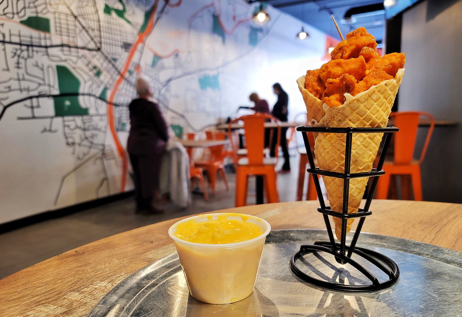 Chick'nCone restaurant has opened at The Marcum in Hamilton. The restaurant features air fried chicken chunks with multiple sauces served in fresh made waffle cones. NICK GRAHAM / STAFF