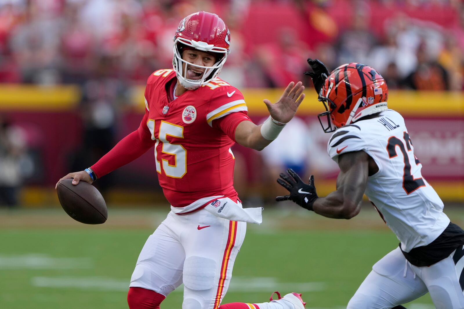 Kansas City Chiefs quarterback Patrick Mahomes (15) runs with the ball as Cincinnati Bengals cornerback Dax Hill (23) defends during the first half of an NFL football game Sunday, Sept. 15, 2024, in Kansas City, Mo. (AP Photo/Charlie Riedel)