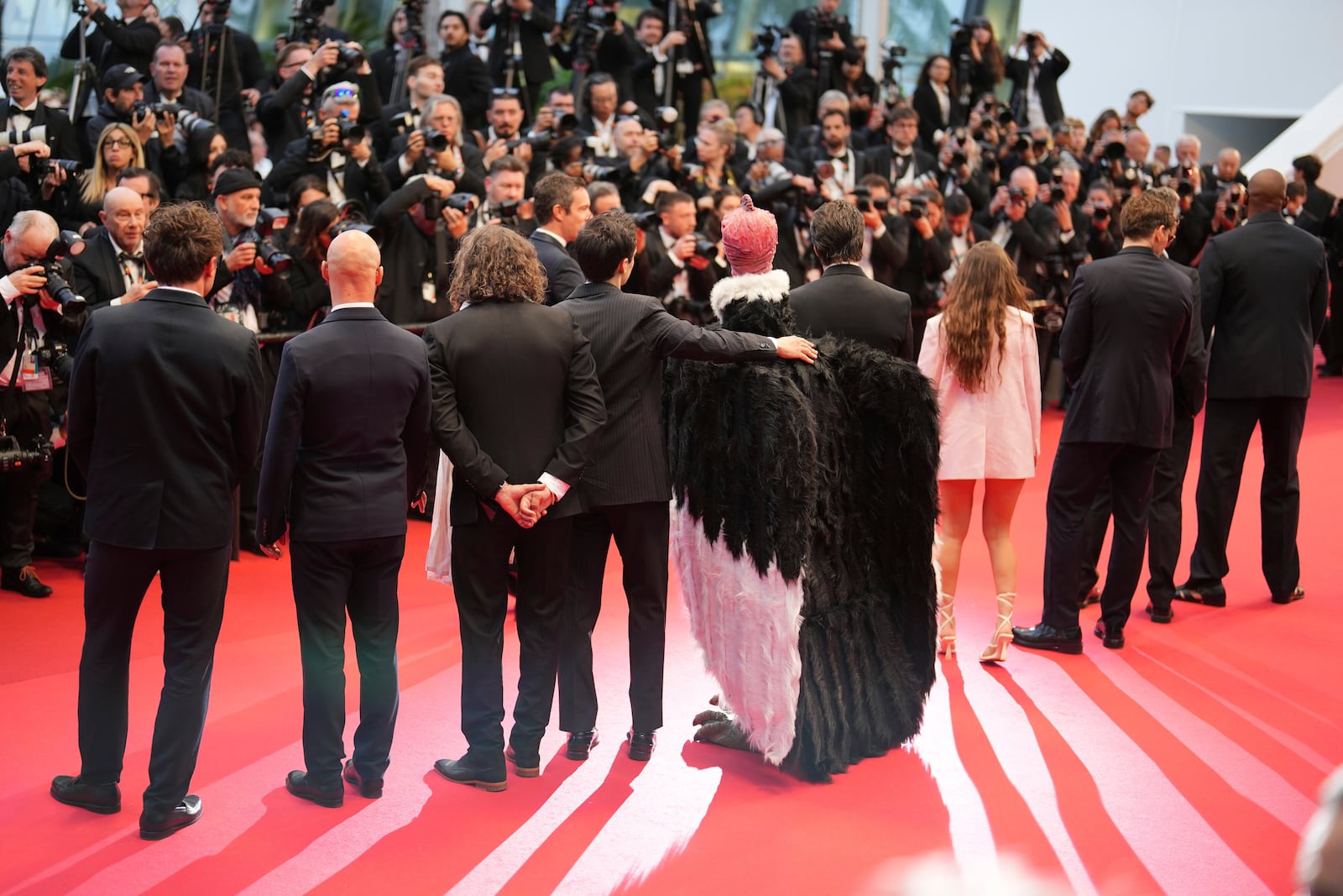 A person dressed in a bird costume, centre, poses for photographers upon arrival at the premiere of the film 'Die, My Love' at the 78th international film festival, Cannes, southern France, Saturday, May 17, 2025. (Photo by Lewis Joly/Invision/AP)