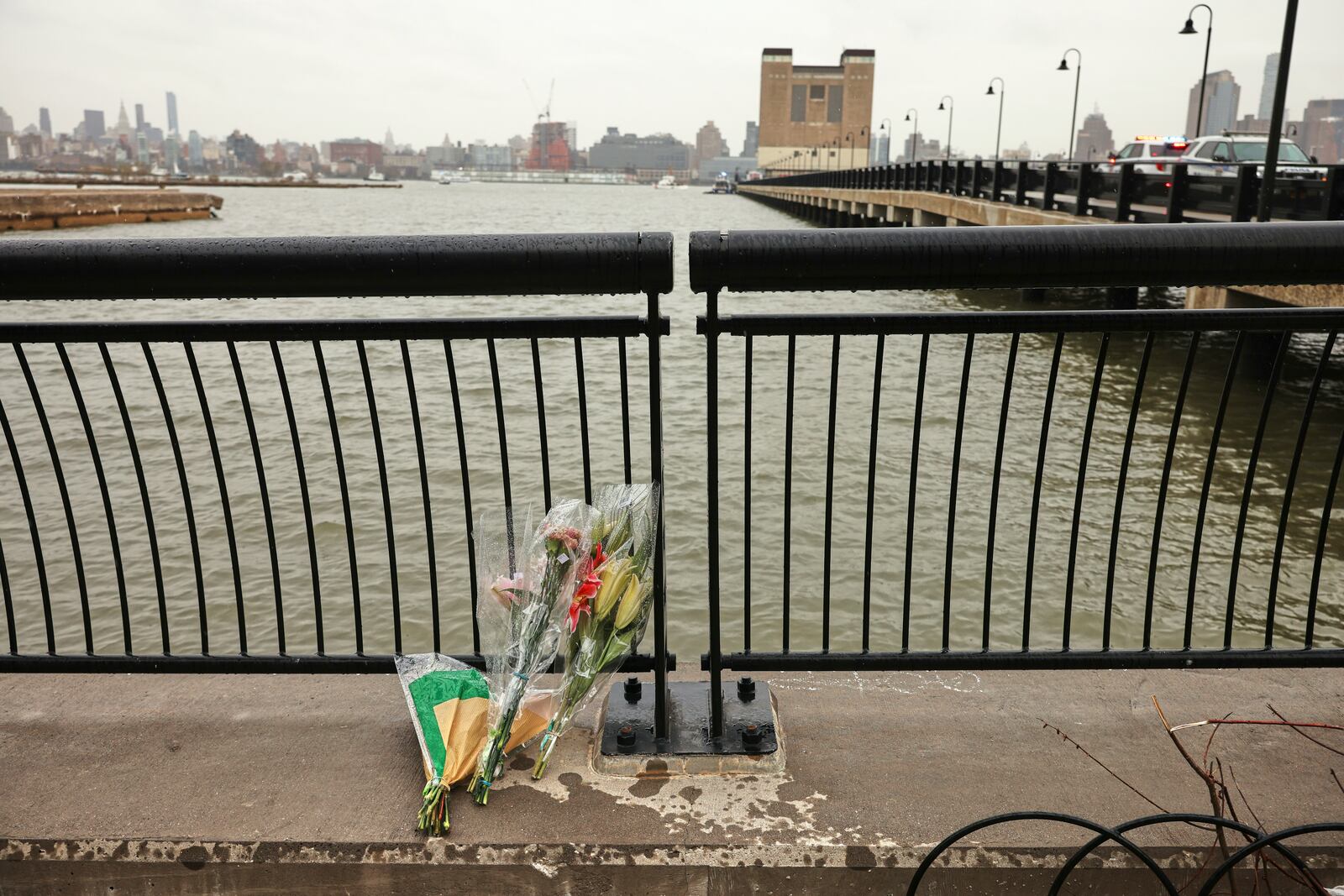 Flowers rest at the end of a pier, Friday, April 11, 2025, near the site where a sightseeing helicopter crashed a day earlier into the Hudson River in Jersey City, N.J. (AP Photo/Yuki Iwamura)