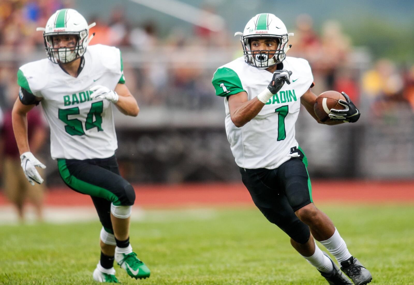 Badin’s Davon Starks carries the ball while trailed by teammate Evan Schlensker during their season-opening 41-20 victory at Ross last Friday. NICK GRAHAM/STAFF
