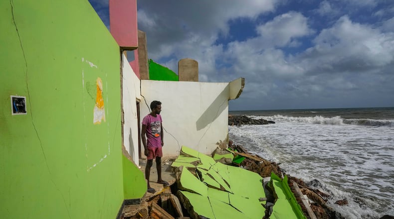 FILE - Dilrukshan Kumara looks at the ocean as he stands by the remains of his family's home in Iranawila, Sri Lanka, June 15, 2023. (AP Photo/Eranga Jayawardena, File)