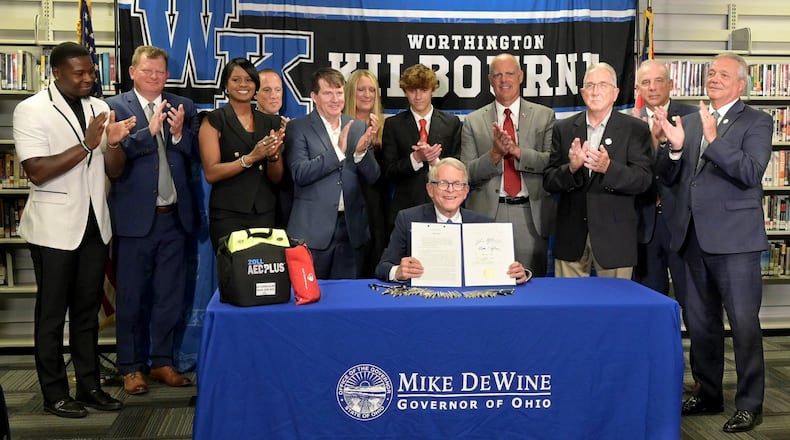 Ohio Gov. Mike DeWine shows off the signed House Bill 47, which will require all public and private schools to have AEDs on site as well as community centers. Contributed