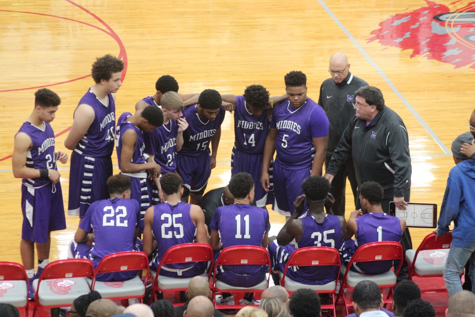 Middletown coach Darnell Hoskins crouches in front of his team during a timeout in Friday night’s game at Lima Senior. CONTRIBUTED PHOTO BY MARITZA MCKINNEY