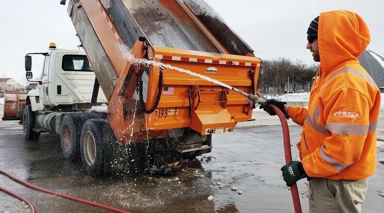 Cole Greer sprays off a salt truck at the Butler County Engineer’s Office Tuesday, Jan. 22 after two weekends of snow in the area. NICK GRAHAM/STAFF