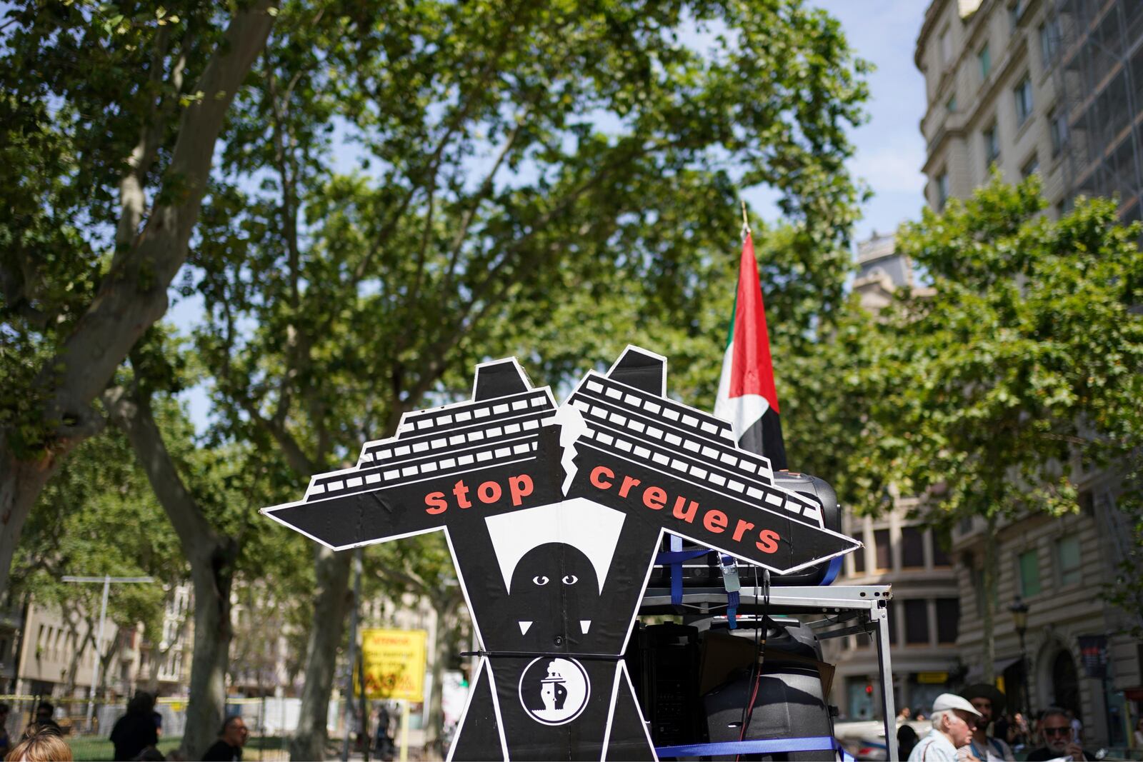 A cardboard figure of a cruise ship is photographed during a protest against overtourism in Barcelona, Spain, Sunday, June 15, 2025. (AP Photo/Pau Venteo)