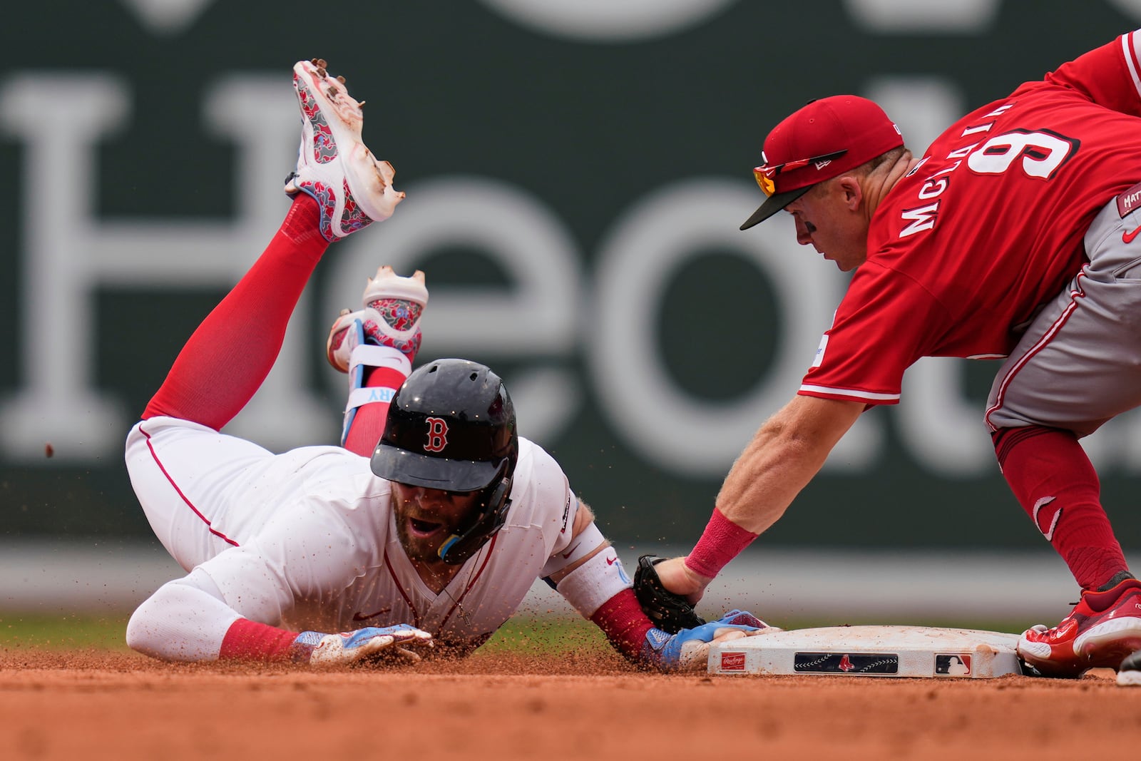 Boston Red Sox's Trevor Story, left, is tagged out by Cincinnati Reds second baseman Matt McLain (9) after over running the base on his RBI double during the eighth inning of a baseball game, a continuation of a game the night before which was suspended due to rain, Wednesday, July 2, 2025, at Fenway Park, in Boston. (AP Photo/Charles Krupa)