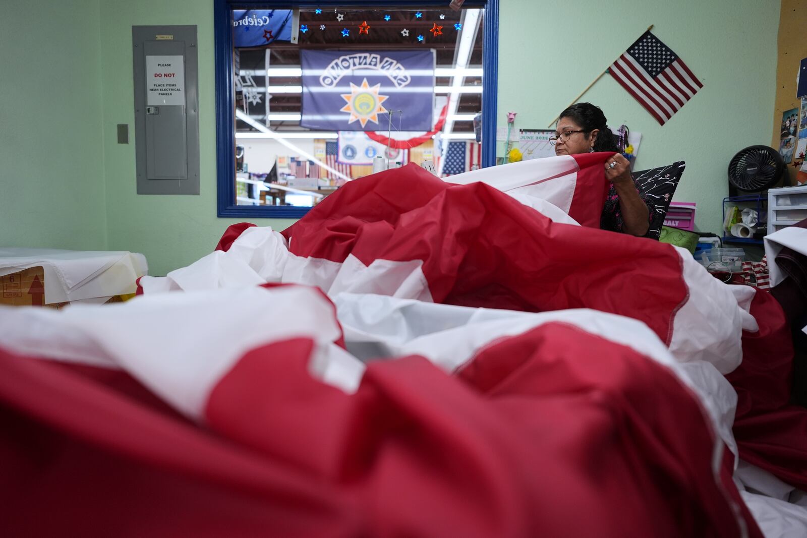 Lucy A. Rodriguez sews the stripes for a large U.S. flag at Dixie Flag and Banner, Tuesday, June 10, 2025, in San Antonio. (AP Photo/Eric Gay)