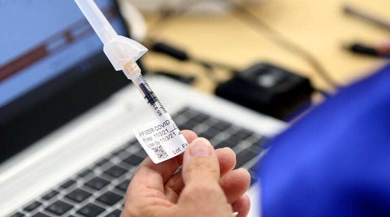 Retired registered nurse Jill Rill holds a syringe containing a child dose of a Pfizer COVID-19 vaccine during the first COVID-19 vaccine clinic in Franklin County for children age 5-11 at Nationwide Children's Hospital in Columbus, Ohio, Wednesday, Nov. 3, 2021. (AP Photo/Paul Vernon)