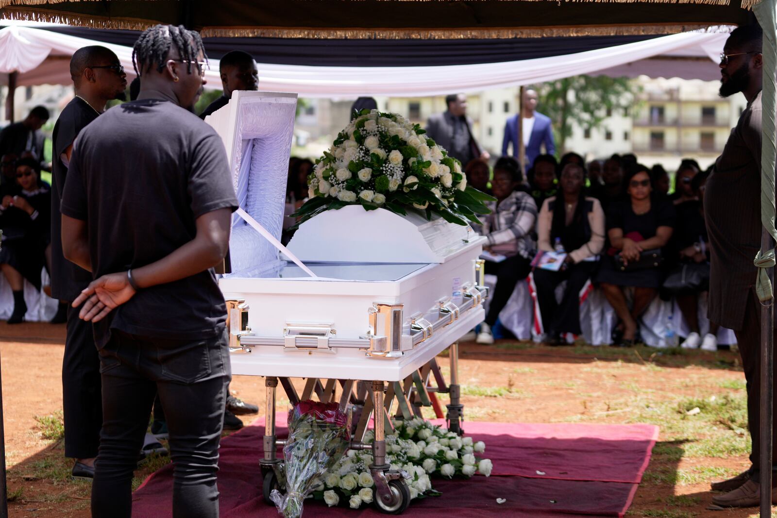 Mourners listen during the funeral service for Nigerian Ladi Anzaki Olubunmi, a TikTok content moderator employed by subcontractor Teleperformance, at the Langata cemetery in Nairobi, Kenya Thursday, April. 17, 2025. (AP Photo/Brian Inganga)