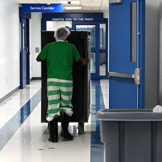Butler County Sheriff Richard Jones has taken a hard stance on immigration since taking office more than two decades ago. He had 10 deputies credentialed to serve as ICE agents in the county, and said he plans to have more deputies eventually go through the training. Pictured is an inmate on Wednesday, July 9, 2025, pushing a cart of food in the hallway at the Butler County Jail. MICHAEL D. PITMAN/STAFF