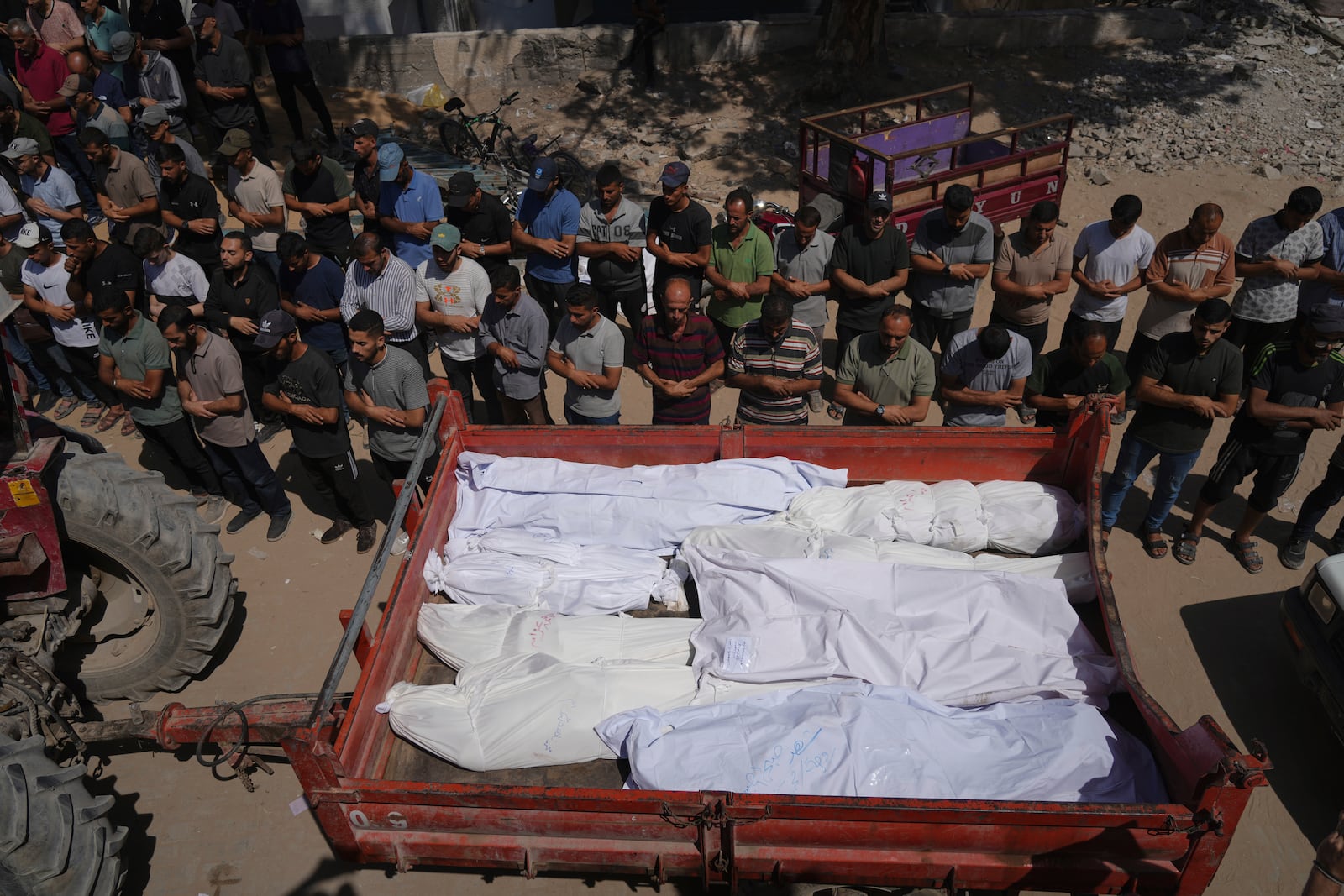 Mourners pray beside the bodies of Palestinians who were killed by an Israeli airstrike, during their funeral at Shifa Hospital in Gaza City Tuesday, July 15, 2025. (AP Photo/Jehad Alshrafi)