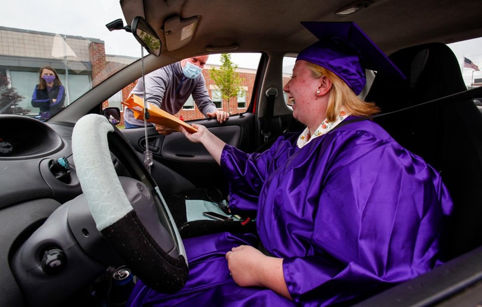 In May, Middletown High School graduates received their diplomas in a drive-by procedure that used coronavirus safe-distancing for the hand off to seniors in front of the school. School officials are now going to hold an in-person, but reduced crowd ceremony this Thursday outside at Barnitz Stadium. (Photo By Nick Graham/Journal-News)