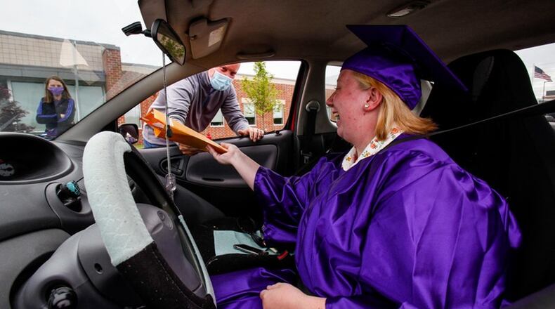 In May, Middletown High School graduates received their diplomas in a drive-by procedure that used coronavirus safe-distancing for the hand off to seniors in front of the school. School officials are now going to hold an in-person, but reduced crowd ceremony this Thursday outside at Barnitz Stadium. (Photo By Nick Graham/Journal-News)