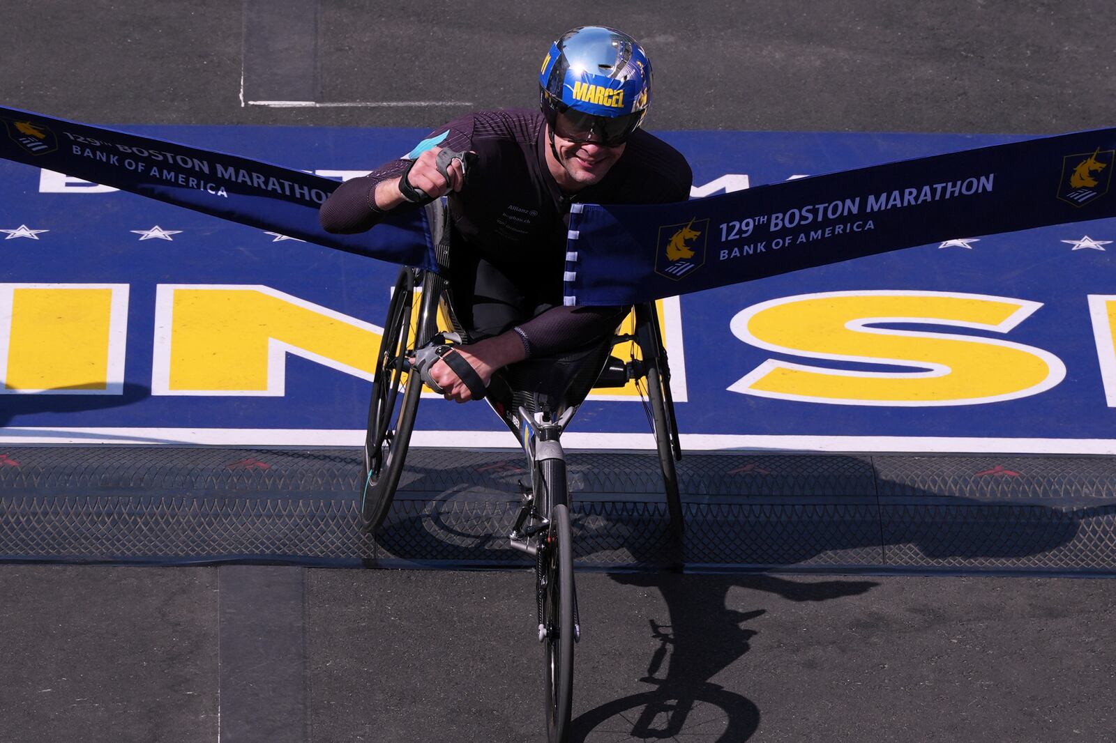 Marcel Hug, of Switzerland, breaks the tape to win the men's wheelchair division during the Boston Marathon, Monday, April 21, 2025, in Boston. (AP Photo/Charles Krupa)