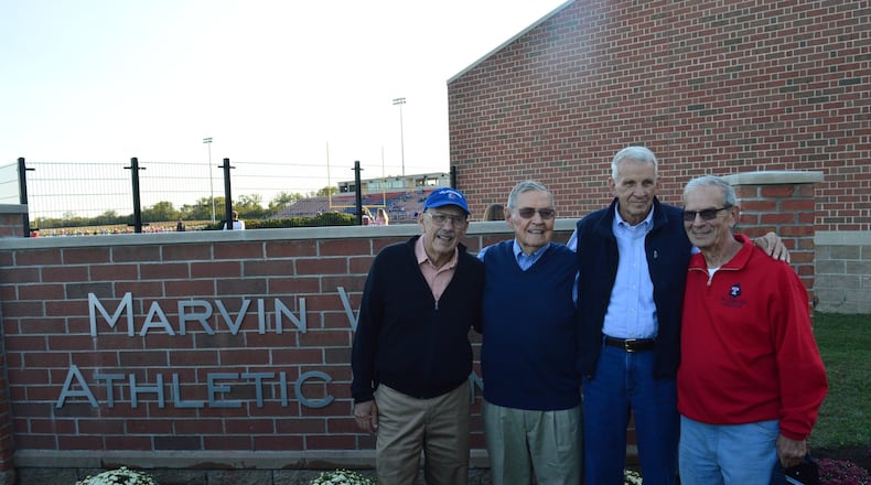Colleagues in coaching, teaching, school administration and friendship (from left) Bill Bowers, Marvin Wilhlem, Dave Butcher and Joe Pyfrin gathered for a photo at the new sign designating the Marvin Wilhelm Athletic Complex at Talawanda High School. CONTRIBUTED/BOB RATTERMAN