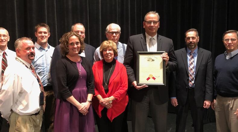 Talawanda Board of Education members received word of a suicide prevention grant provided to the district at a meeting and posed with staff and community members responsible for obtaining it. The money is being used to fund the Hope Squad program at the high school. CONTRIBUTED