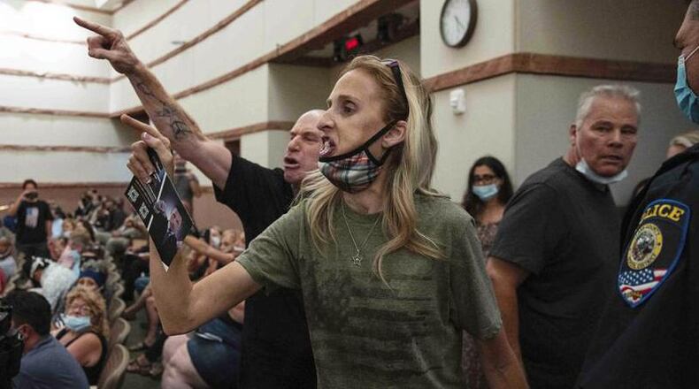 The coming new year may see a lull in some of the uproar at area school board meetings over Covid policies and other issues, say education leaders. In this Aug. 12, 2021 file photo, protesters against a COVID-19 mandate gesture as they are escorted out of the Clark County School Board meeting at the Clark County Government Center, in Las Vegas. Similar scenes have played out in some Butler County school districts during a few school board meetings in 2021. (File Photo\Journal-News)