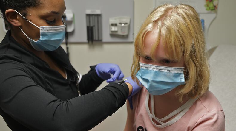 Lily True, 9, gets her COVID-19 vaccine shot at the Rocking Horse Center in Springfield earlier this month. BILL LACKEY/STAFF