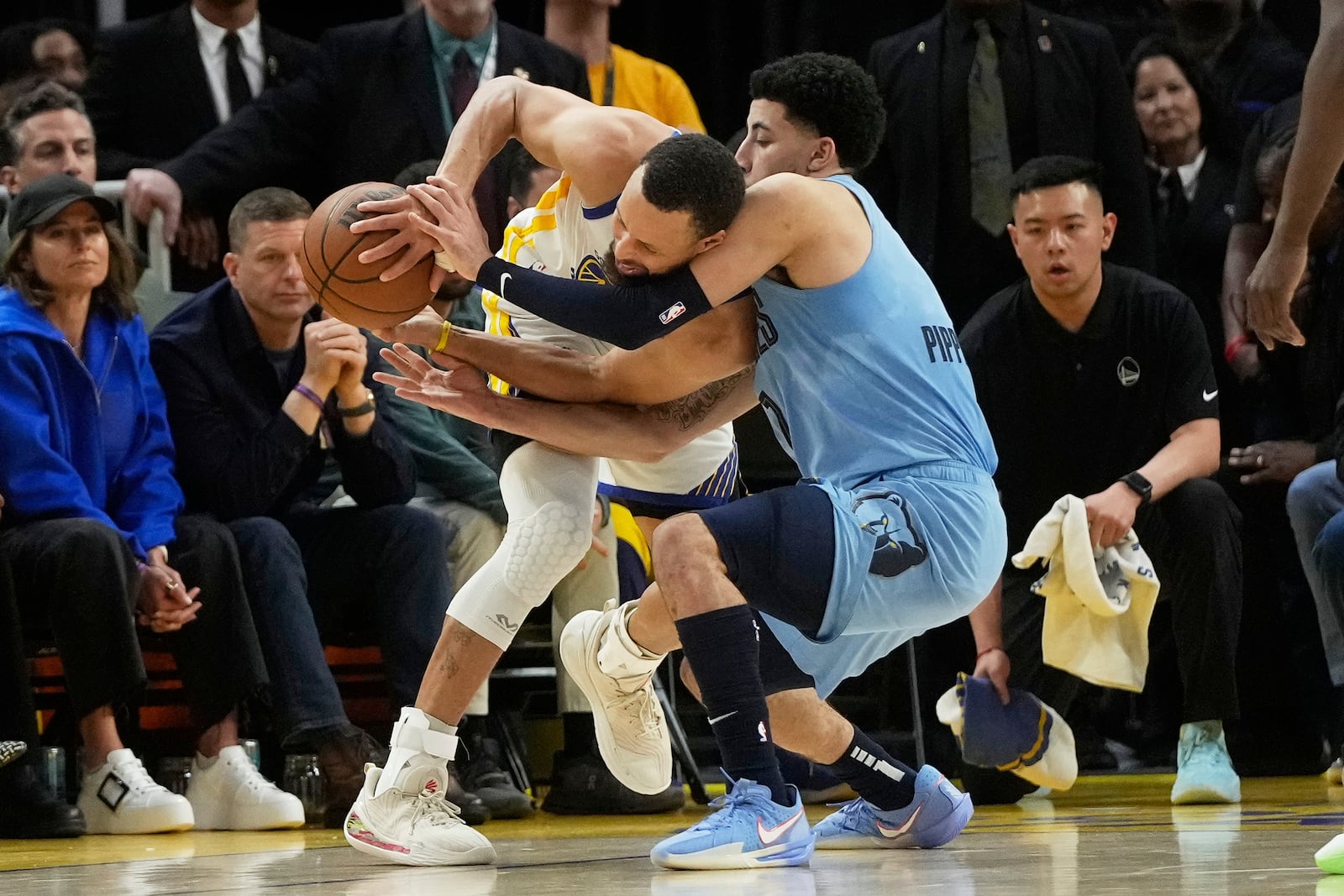 Golden State Warriors guard Stephen Curry, middle left, is defended by Memphis Grizzlies guard Scotty Pippen Jr. during the second half of an NBA play-in tournament basketball game in San Francisco, Tuesday, April 15, 2025. (AP Photo/Jeff Chiu)