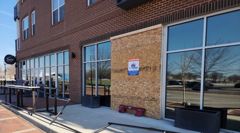 Tano Bistro, 150 Riverfront Plaza, Hamilton, is making repairs to some of its windows after a vehicle backed into it on Sunday, March 5, 2023. Pictured is a plywood panel on Monday, March 6, 2023, covering the whole until repairs can be made. NICK GRAHAM/STAFF