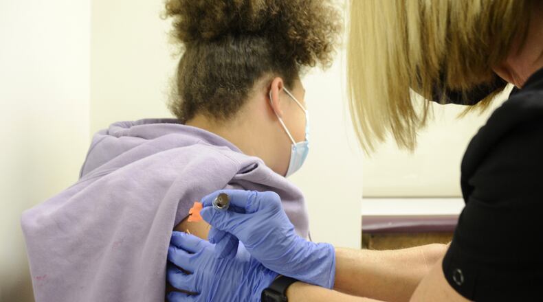 Brooklyn Brundidge, 12, a seventh-grader at Garfield Middle School in Hamilton, receives a vaccine shot on Wednesday, Sept. 14, 2022, from Public Health Nurse Betsy Waldeck at the Butler County General Health District clinic in downtown Hamilton. MICHAEL D. PITMAN/STAFF