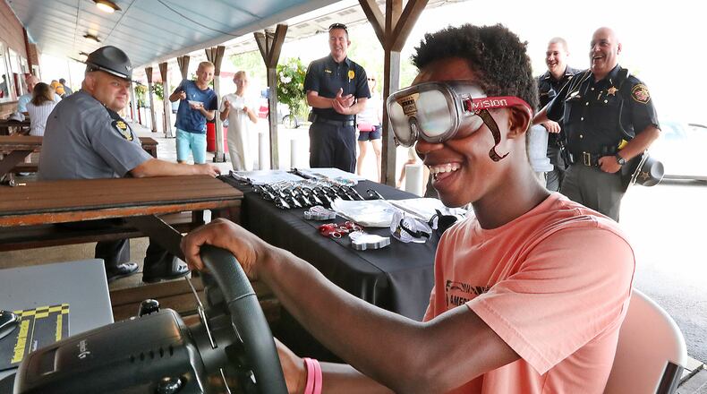 Pierre Bowman tries to operate a driving simulator with a pair of Fatal Vision, drunk goggles, during the 2021 Drive Sober or Get Pulled Over campaign kickoff at Youngs Jersey Dairy. A driving simulator will be in downtown Lebanon on Saturday, Aug. 19, 2023 to kick off the 2023 event in Warren County. BILL LACKEY/STAFF