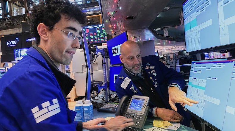 Specialists Alex Weitzman, left, and Meric Greenbaum work on the floor of the New York Stock Exchange, Thursday, Dec. 11, 2025. (AP Photo/Richard Drew)