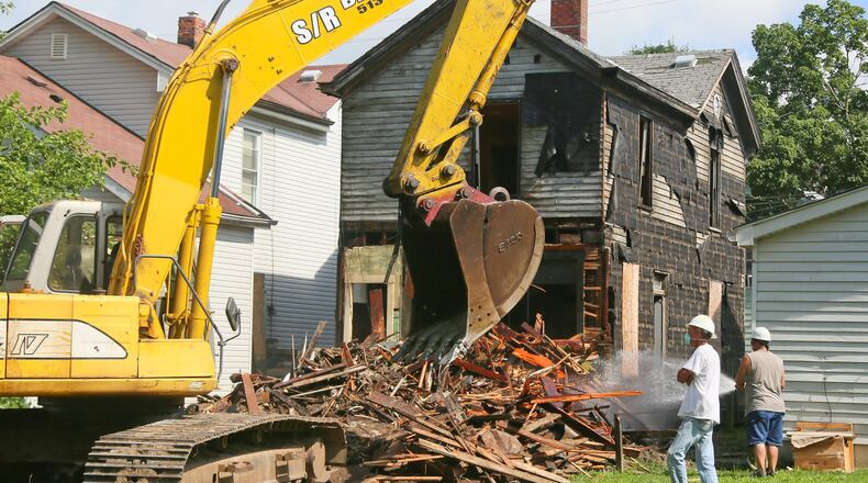 Demolition crews tear down a house at 335 Hanover St. in Hamilton this past July. GREG LYNCH / STAFF