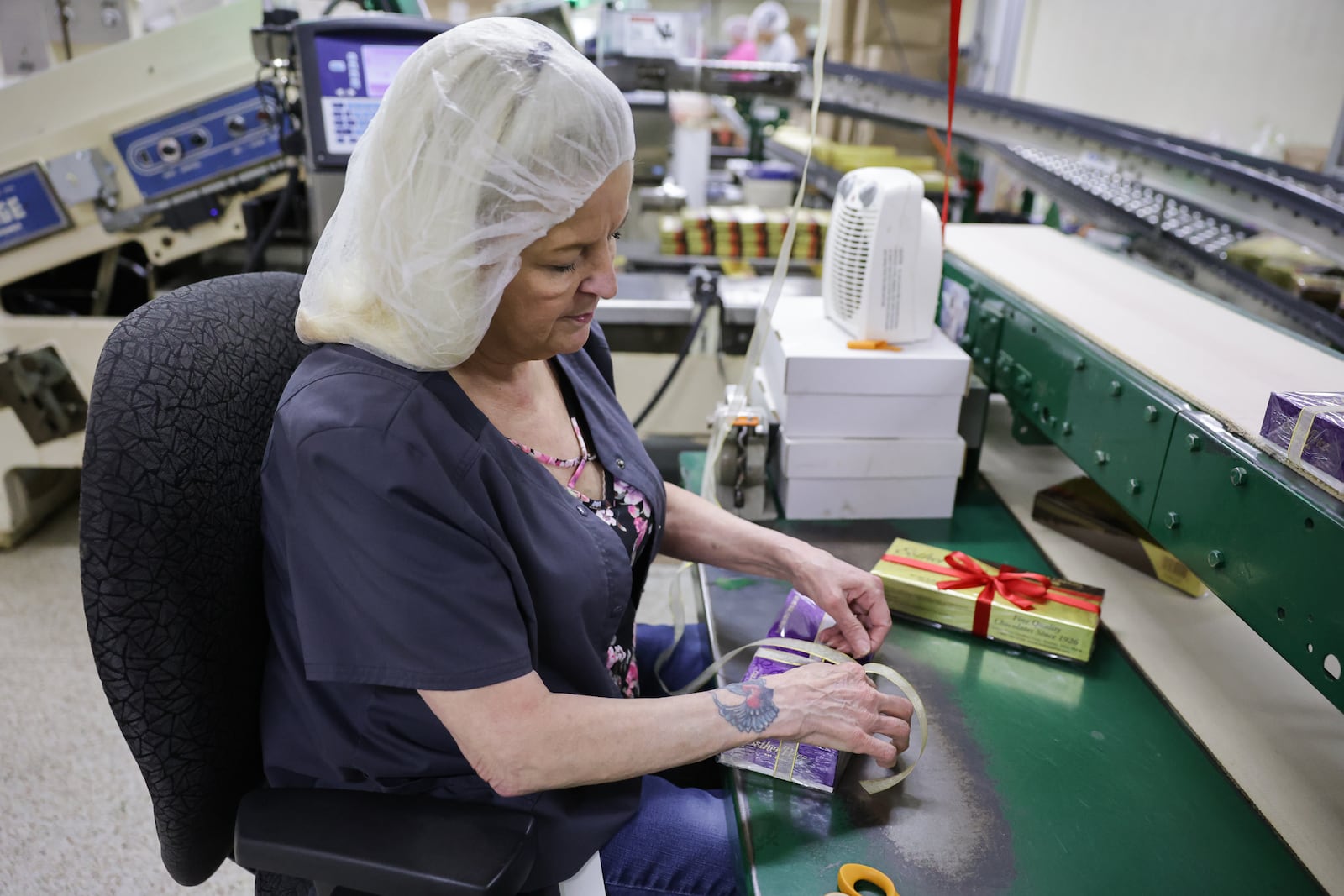 Linda Bell, an Esther Price employee, ties a bow on a special 100th anniversary box. Bell hand-ties an estimated 250,000 bows a year. BRYANT BILLING / STAFF