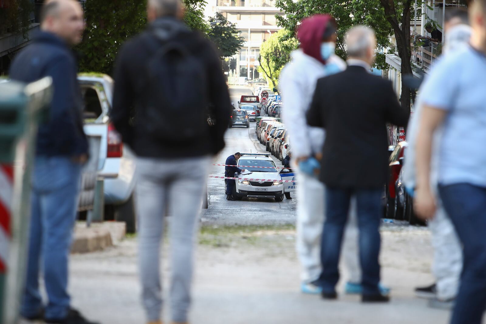 Greek policemen and forensic experts are seen at the area where a 38-year-old woman was killed early Saturday when a bomb she was carrying exploded in her hands outside a bank branch, local police said, in Thessaloniki, northern Greece, May 3, 2025. (AP Photo/Giannis Papanikos)