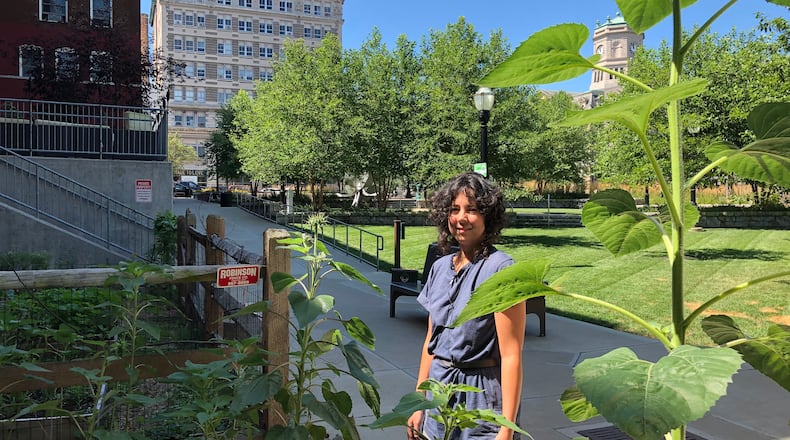 Laurana Wong, a Hamilton artist, works on a garden she and others have created near the Artspace Lofts in the downtown area. MIKE RUTLEDGE/STAFF