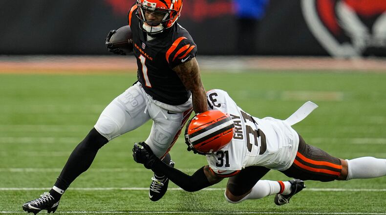 Cincinnati Bengals wide receiver Ja'Marr Chase (1) is tackled by Cleveland Browns safety Vincent Gray (31) as he runs after a catch during the first half of an NFL football game in Cincinnati, Sunday, Jan. 7, 2024. (AP Photo/Sue Ogrocki)