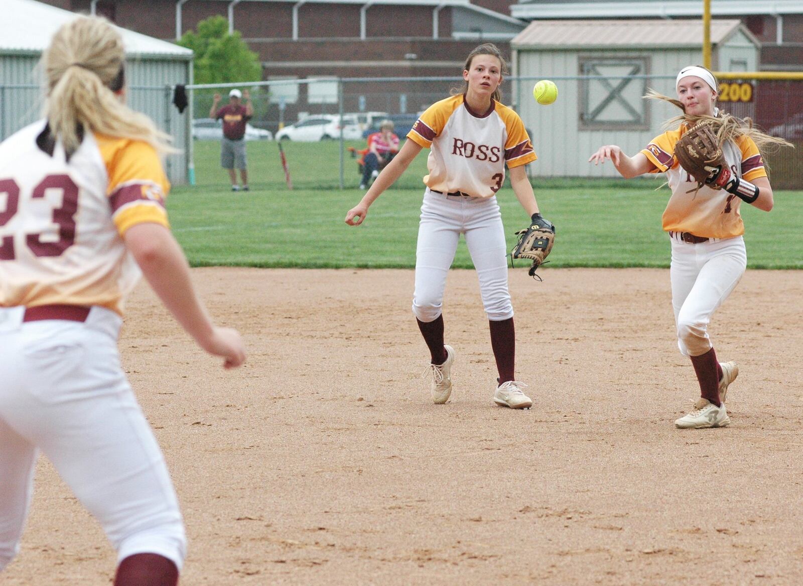 Ashley Shelton of Ross throws to first baseman Bailee Gunnell (23) as pitcher Madison Minges (3) watches Tuesday during a Division II sectional softball game against visiting Wyoming. Ross won 17-4 in five innings. RICK CASSANO/STAFF