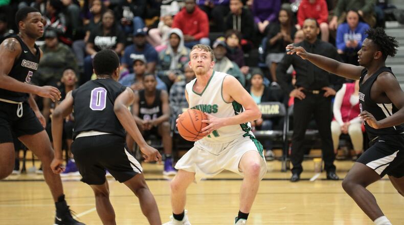 New Miami’s Nate Hobbs finds himself surrounded by Gamble Montessori defenders last Saturday night at Taylor. New Miami won the Division IV district basketball semifinal 48-47. PHOTO BY KRAE/WWW.KRAEPHOTOGRAPHY.COM
