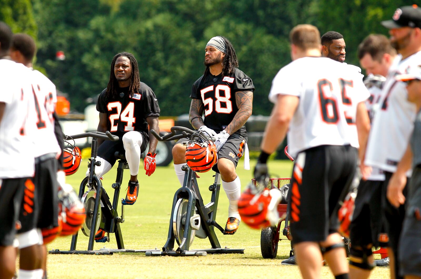 Cincinnati Bengals cornerback Adam Jones (24) and Rey Maualuga (58) use the exercise bikes during training camp practice Tuesday, Aug. 5, 2014, in downtown Cincinnati. NICK DAGGY / STAFF