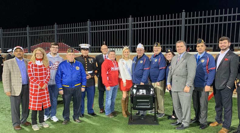 Ohio Senator Bill Coley (R-Liberty Twp.) - third from right - joined Miami University President Gregory Crawford and his wife Renate along with nearly a dozen area and state officials in dedicating a memorial chair Wednesday honoring the nation’s prisoners of war and those missing in action. The chair, which will be installed in Miami’s Yager Stadium on the school’s Oxford campus, will be placed in the south stands next year. (Provided Photo/Journal-News)