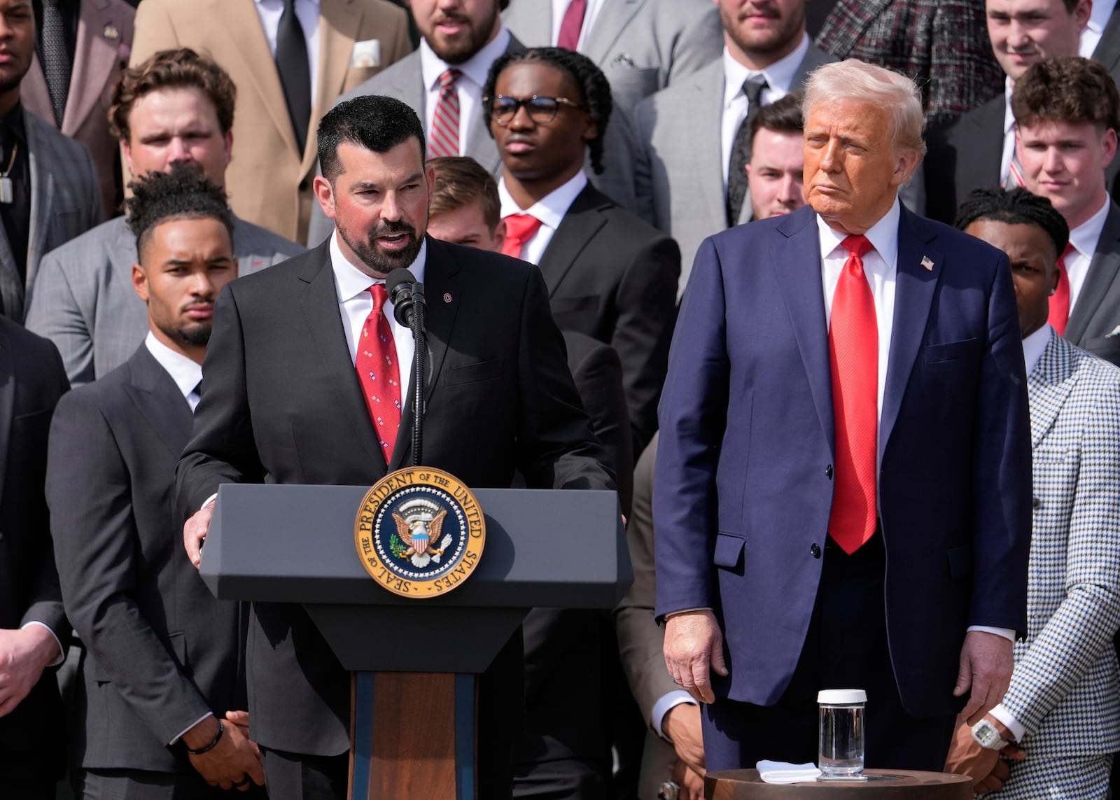 Ryan Day, head coach of the Ohio State University football team, speaks as President Donald Trump listens during an event welcoming the 2025 College Football National Champions, the Ohio State University football team, on the South Lawn of the White House, Monday, April 14, 2025, in Washington. (AP Photo/Manuel Balce Ceneta)