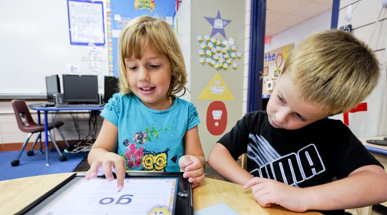 Monroe Local Schools starts a new school year Wednesday, Aug. 16. In this 2012 file photo, kindergartners at Monroe Primary School use an iPad to learn letters and words. NICK GRAHAM/2012