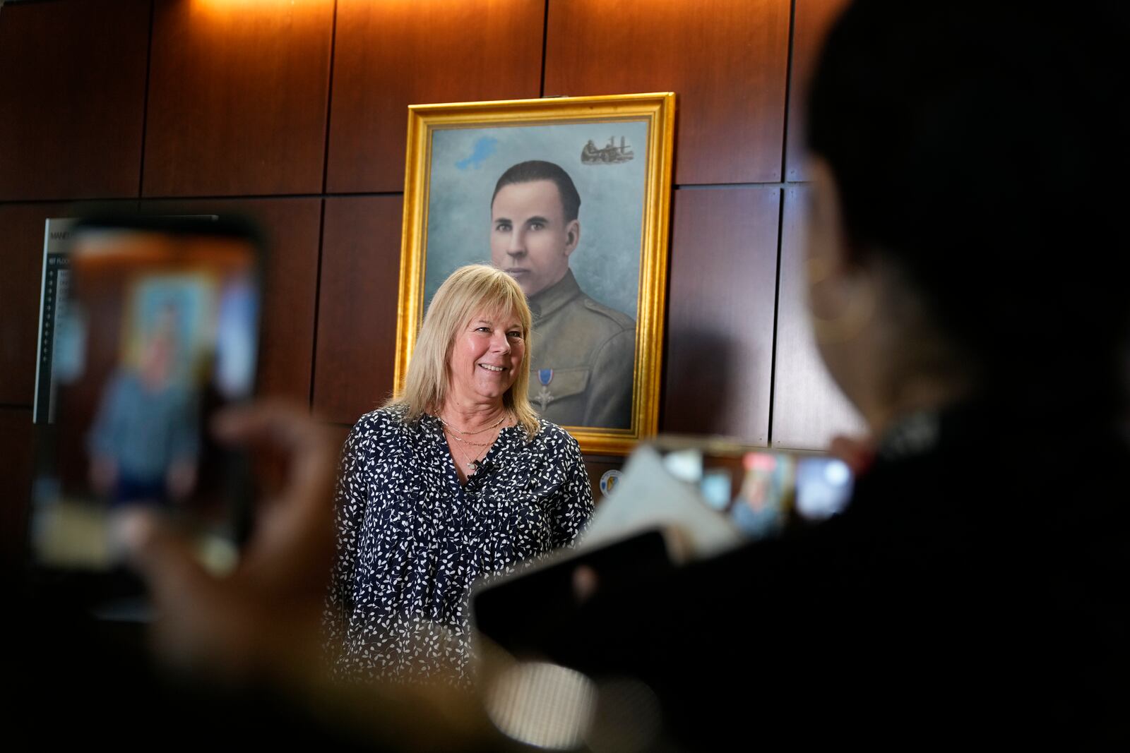 Ms. Sue Conger-Williams, Fred Benning's granddaughter gives and interview in front of her grandfathers portrait hanging at Fort Benning during a ceremony honoring new namesake on Wednesday, April 16, 2025, in Fort Benning, Ga. (AP Photo/Brynn Anderson)