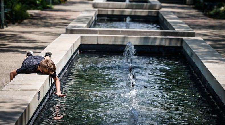 Thomas Phillips, from Dayton, enjoys the fountains at RiverScape MetroPark on Monument Ave. in downtown Dayton Wednesday July 5, 2023. JIM NOELKER/STAFF